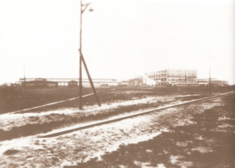 Bouw van de Philips fabriek in 1929. Links is men reeds gestart met de productie van transformatoren en spoelen in houten loodsen. Rechts de eerste verdiepingen van de hoogbouw in opbouw. Dwars over het plein heeft men een stoomtramlijn aangelegd voor de aanvoer van bouwmaterialen.