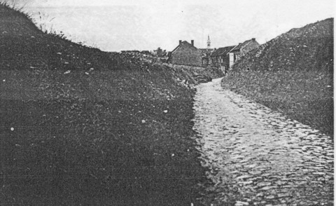 De Hertogstraat liep van de Naamsesteenweg bergop naar het militair oefenterrein. Het was in die tijd niet meer dan een gekasseide holle weg. Op de achtergrond de kerk van Heverlee. (foto rond 1950)